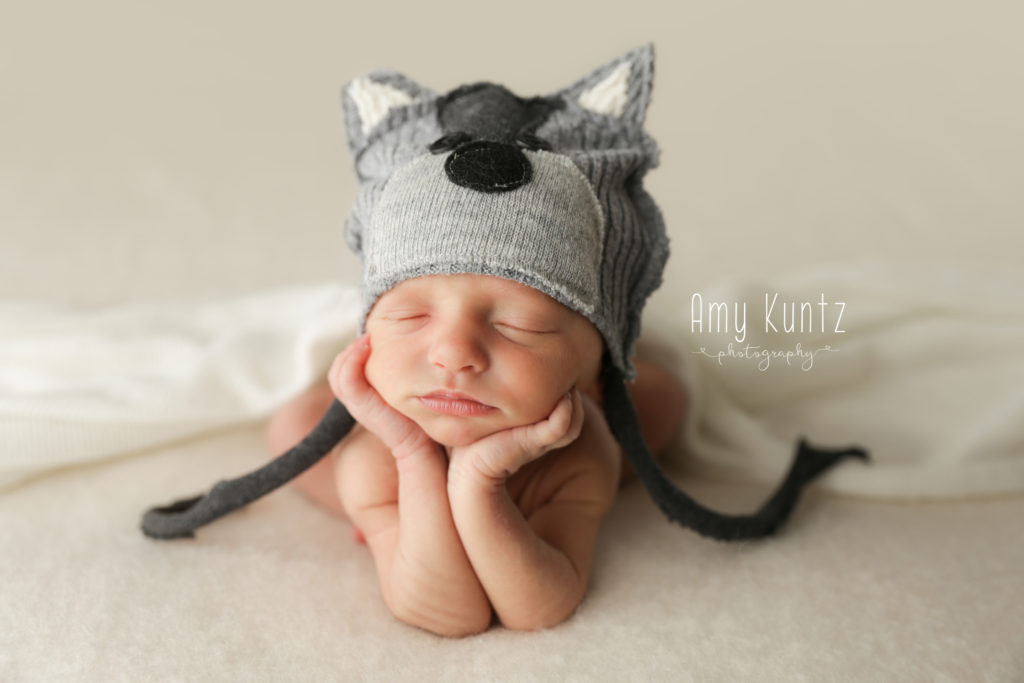 Baby boy in froggy pose with a wolf hat