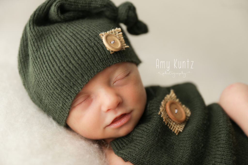 newborn photo shoot with a baby boy in a romper
