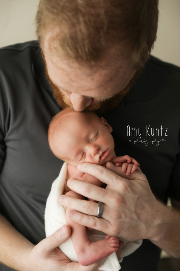 dad and his son at a newborn photo session with kansas city's best newborn photographer