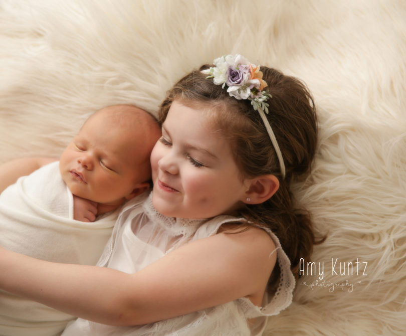 baby boy and his sister at a newborn photo session