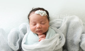 newborn baby girl wrapped in blue photo session