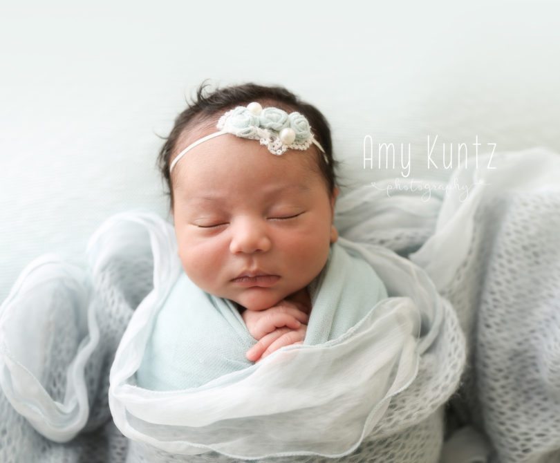 newborn baby girl wrapped in blue photo session
